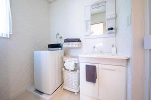 małą białą łazienkę z umywalką i lustrem. w obiekcie Minamitsuru-gun - House - Vacation STAY 83637 w mieście Fujikawaguchiko