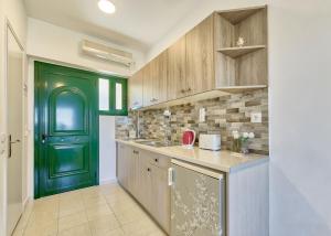 a kitchen with a green door and a counter at Artemis Hill Studios in Argasi