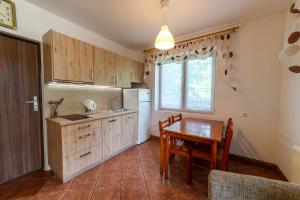 a kitchen with a table and a refrigerator and a dining room at Willa ATA Mikolajki in Mikołajki