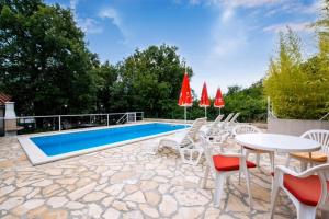 a patio with a table and chairs and a pool at Apartment Vinez in Labin