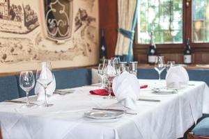 a table with white table cloths and glasses on it at PLAZA Hotel Buchhorner Hof in Friedrichshafen