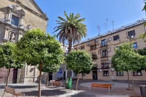 a park with benches and trees in front of a building at SunShine Vista al Compás in Córdoba