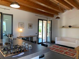 eine Küche und ein Wohnzimmer mit einem Kochfeld in der Unterkunft Villa Aloe in Menfi