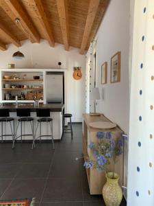 a kitchen with white walls and a counter with chairs at Villa Aloe in Menfi