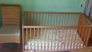 a wooden crib in a room with a bed at Ferienwohnungen Rosi in Kleblach