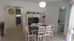 een eetkamer met een tafel en stoelen en een televisie bij APARTAMENTO ROMA XI in Playa de Gandia