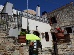 Kalón Khoríon的住宿－Jean's Cretan Cottage，坐在大楼前门上的绿伞