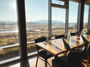 a dining room table with chairs and a window at Hofsstadir - Country Hotel in Hofstaðir