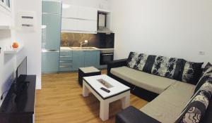 a living room with a couch and a table at Sunset House in Ksamil