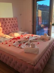 a large bed with red flowers on top of it at Sunset House in Ksamil +84 photos