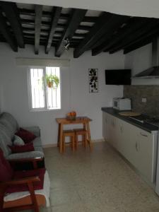 cocina y sala de estar con sofá y mesa en Casa López, en Vejer de la Frontera