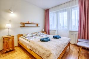 a bedroom with a bed with two blue pillows on it at Apartament Albatros in Władysławowo