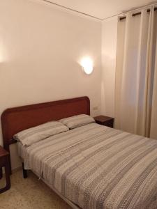 a bedroom with a bed with a striped comforter at Apartamento Rey-Piscina in Denia +86 photos