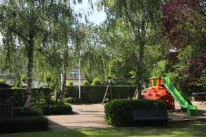 een speeltuin met een groene glijbaan in een park bij De Biesenberg in Ulestraten