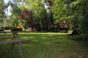 a park with a picnic table and a playground at De Biesenberg in Ulestraten