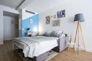 um quarto com uma cama e uma parede azul e branca em T2 cosy Port de plaisance Parking-wifi gratuit em Rochefort