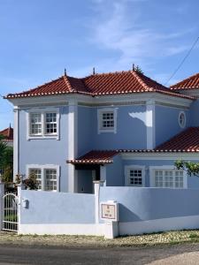 a blue house with a white fence in front of it at Ericeira -Oceonview Villa with Pool and Whirlpool in Mafra