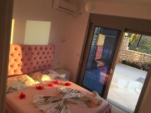 Sunset House في كساميل: غرفة نوم مع سرير مع زهور حمراء عليه