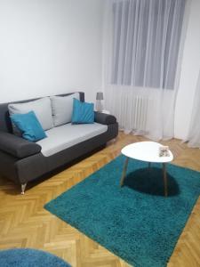 ein Wohnzimmer mit einem Sofa und einem Tisch in der Unterkunft LARA in Užice