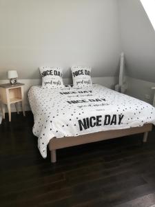 a bed with a nice day comforter and pillows on it at La maison de la Vallée in Froissy