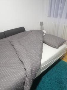 een bed met een grijs dekbed en kussens erop bij LARA in Užice