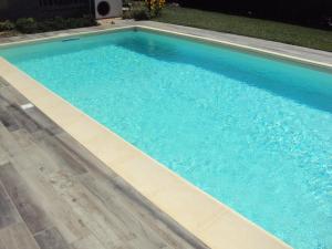 a large swimming pool with blue water at Springs Loft in Candelo