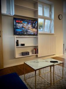 - un salon avec une télévision et une table basse dans l'établissement Apartament Glamour, à Toruń