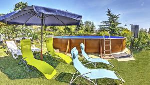 eine Gruppe von Stühlen und einem Sonnenschirm neben einem Pool in der Unterkunft Villa Summer House in Sweti Konstantin