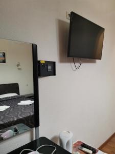 a tv on a wall in a room with a bed at Guesthouse Aragats in Adler