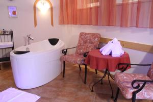 łazienka z wanną, stołem i krzesłem w obiekcie Landhaus Grünberg w mieście Obsteig +37 zdjęć