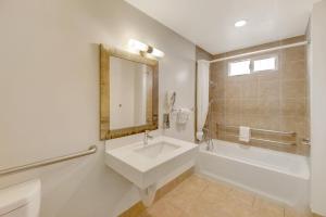 a bathroom with a sink and a tub and a mirror at Hotel 414 Anaheim in Anaheim