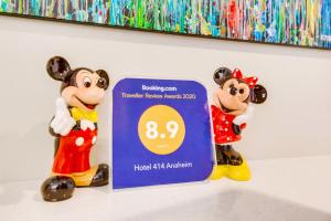 two mickey mouse figurines standing next to a sign at Hotel 414 Anaheim in Anaheim