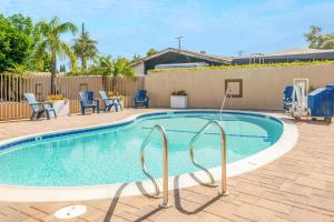 a swimming pool with blue chairs around it at Hotel 414 Anaheim in Anaheim
