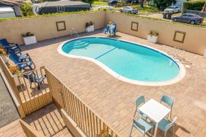 an image of a swimming pool with chairs and a table at Hotel 414 Anaheim in Anaheim