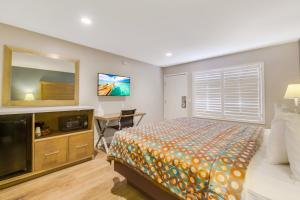 a bedroom with a bed and a flat screen tv at Hotel 414 Anaheim in Anaheim