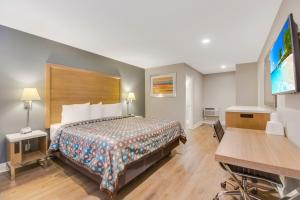 a hotel room with a bed and a flat screen tv at Hotel 414 Anaheim in Anaheim