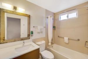 a bathroom with a sink and a toilet and a bath tub at Hotel 414 Anaheim in Anaheim