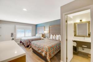 a hotel room with two beds and a sink at Hotel 414 Anaheim in Anaheim