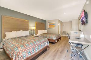 a hotel room with two beds and a desk at Hotel 414 Anaheim in Anaheim