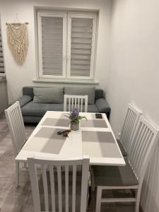 uma mesa de jantar branca com cadeiras e um sofá em VIP Apartments em Krosno Odrzańskie