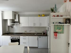 a kitchen with white cabinets and a white refrigerator at Casa Mary in Granadilla de Abona