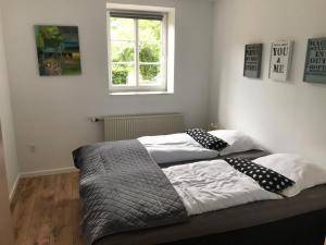 a bedroom with two beds with pillows and a window at Familiehuis Boysen Appartementen in Ribe