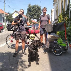 twee personen en een hond met een fiets en een kar bij Base Camp - Urban Guerrilla in Negotin