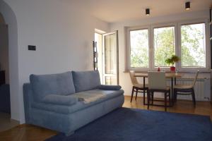 uma sala de estar com um sofá azul e uma mesa em Apartament Kolejowa em Bialystok