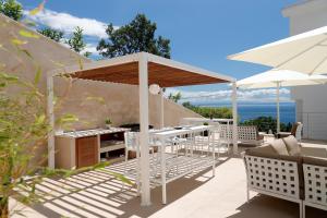 um pátio com um gazebo, uma mesa e cadeiras em MODENA MARIS-heated pool-grill-relax-jacuzzi apartments em Ičići