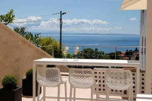 イチチにあるMODENA MARIS-heated pool-grill-relax-jacuzzi apartmentsの白いテーブルと椅子、海を望むバルコニー