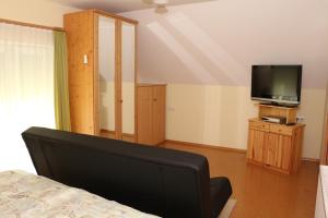 a bedroom with a bed and a flat screen tv at Ferienwohnung Moni in Geiseldorf