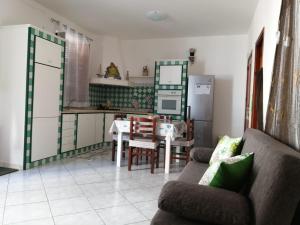 sala de estar con sofá, mesa y cocina en Casa Amaranto, en Terrasini