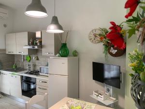 a kitchen with a white refrigerator and a tv at Think Green in Vico dʼElsa