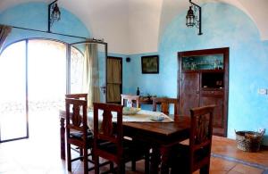 a dining room with a wooden table and blue walls at Dammusi di Sofia in Pantelleria